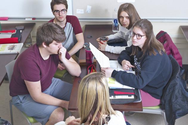 Group of students discussing at a desk