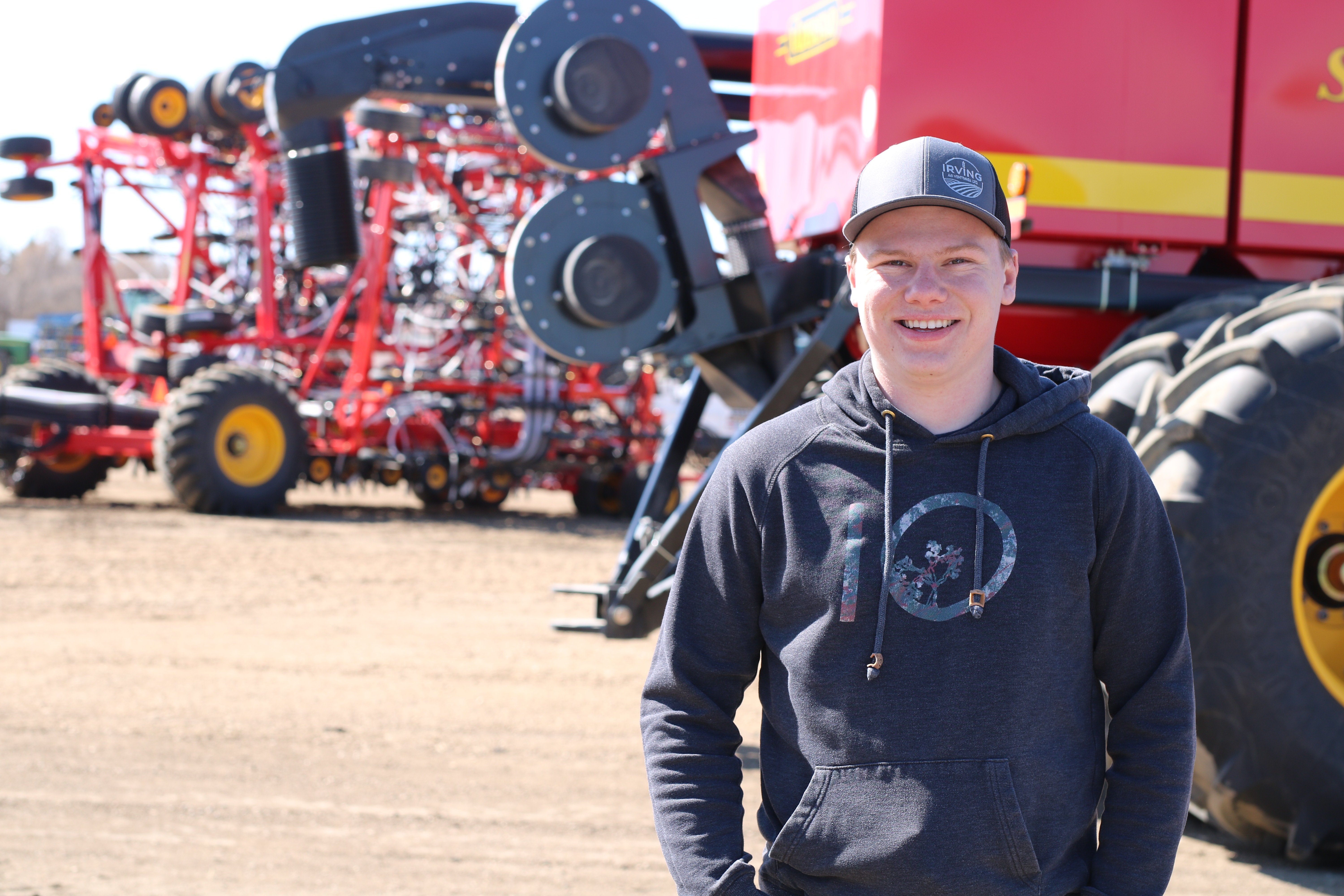 Agricultural Science student standing in front of a combine 