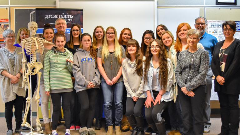 A group of students posing in a classroom with some faculty for the biggar scholorship reception