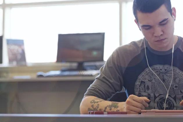 Male student studying with earbuds