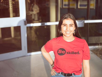 woman posing with a read shirt reading "be skilled"